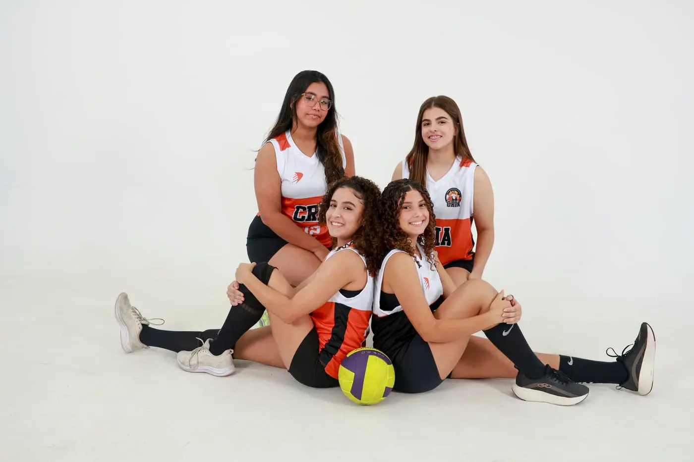 Atletas do vôlei dos Crias sentadas no chão com a bola