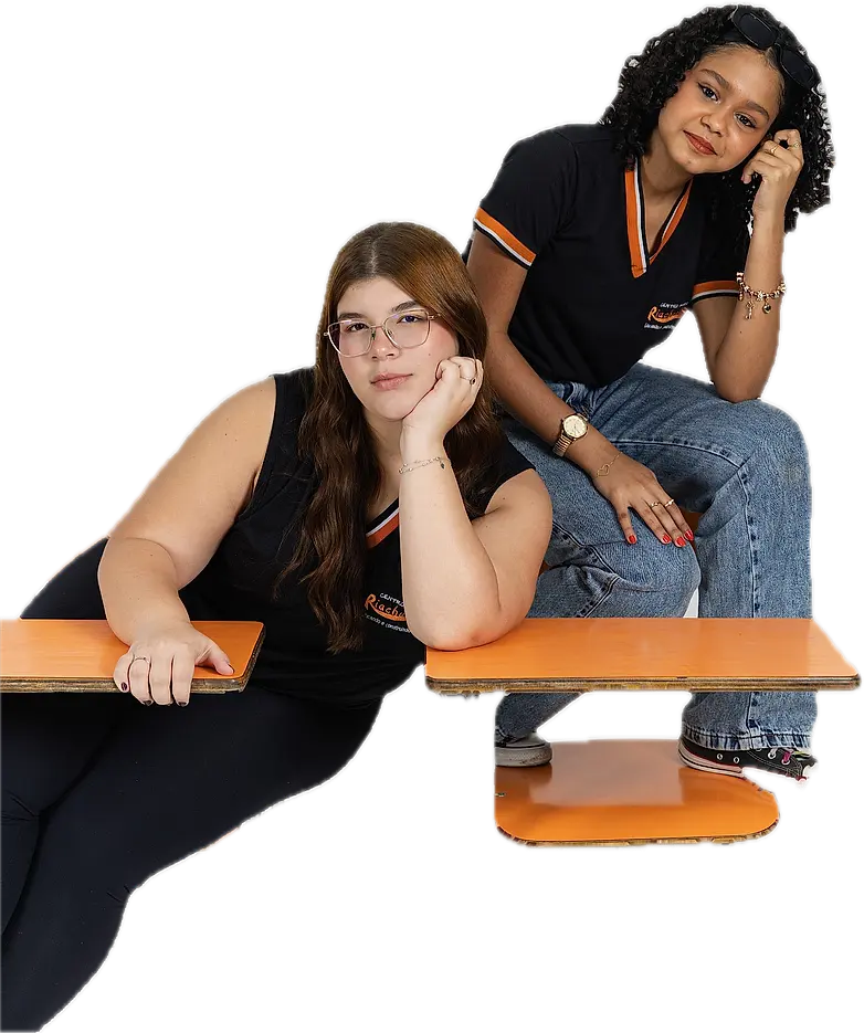 Duas alunas do Ensino Médio sentadas nas carteiras, conversando