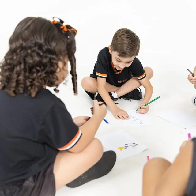 Crianças desenhando juntas no chão