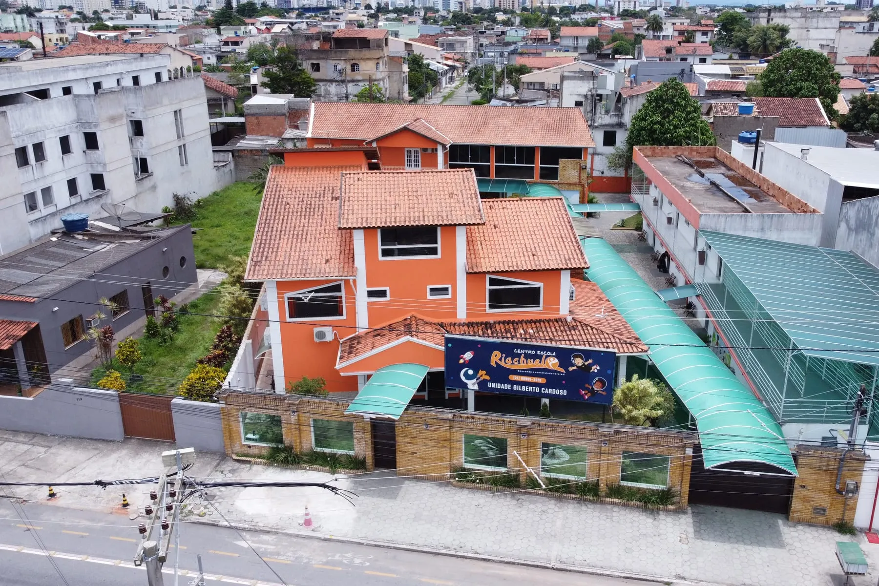 Vista de cima da unidade Gilberto Cardoso, casarão laranja com a quadra coberta ao lado